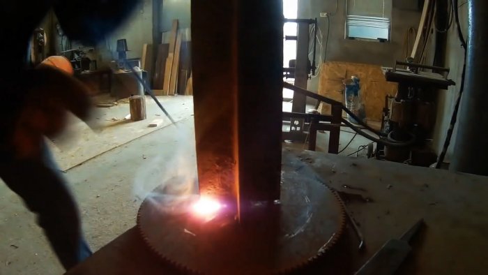 Из двух уголков и маховика сделал полезное приспособление для колки дров