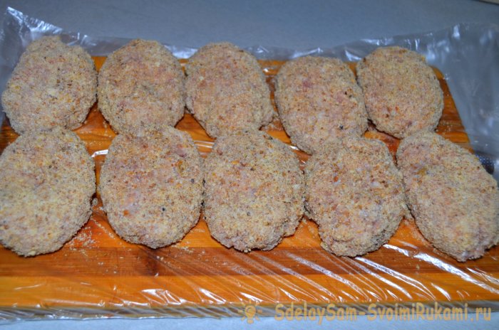 Котлеты обваливают в сухарях и укладывают на разделочную доску в один ряд
