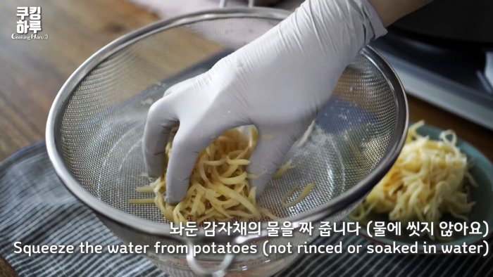 Шинкованный картофель выкладываем на сито и отжимаем