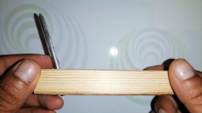 нужно просверлить отверстие в бруске под углом и вставить гвоздь