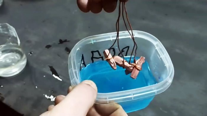 Детали на проволоке опускаются в медный электролит