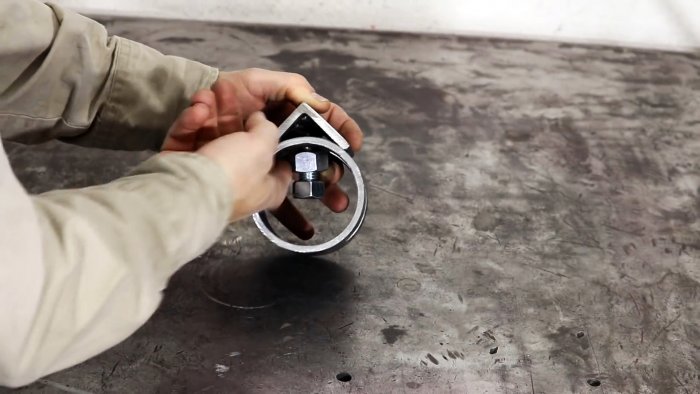 Уголок с болтом вставляется в прорезь в трубе и фиксируется гайками